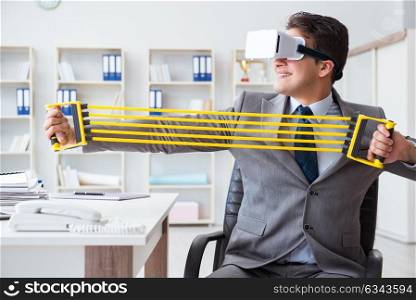 Businessman exercising with elastic expander wearing VR glasses. The businessman exercising with elastic expander wearing vr glasses