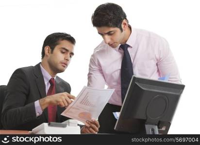 Businessman explaining document to his male colleague