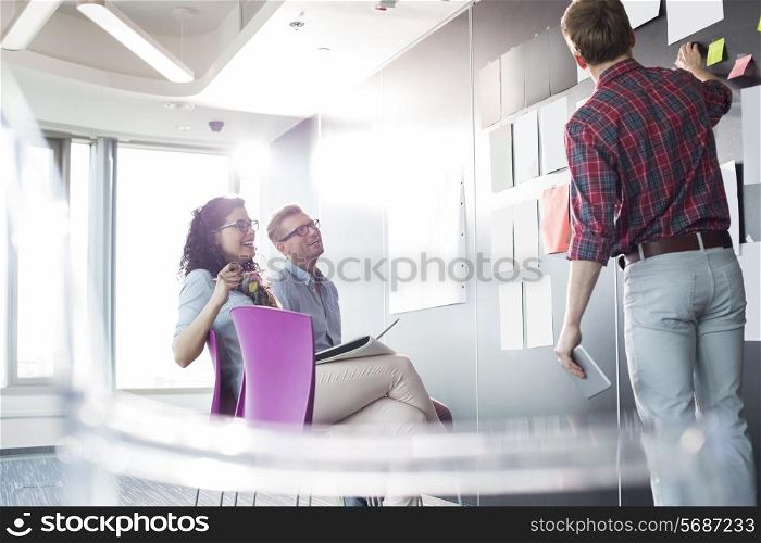 Businessman explaining documents to colleagues in creative office
