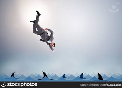 Businessman falling into sea with sharks
