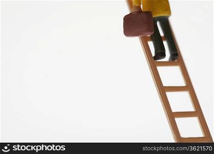 Businessman figurine climbing ladder, low section