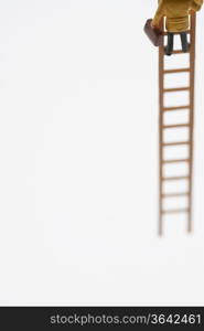 Businessman figurine climbing ladder, low section