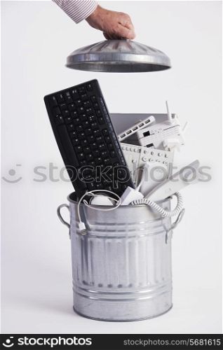 Businessman Filling Garbage Can With Obsolete Office Equipment