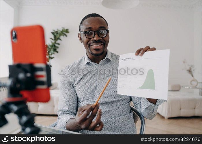 Businessman financial analyst presenting statistics speaking on online working conference by video call, using smartphone. Business coach showing chart, recording on phone educational economic webinar. Businessman financial analyst shows statistics speaking on working conference by phone video call
