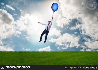 Businessman flying balloons on bright day