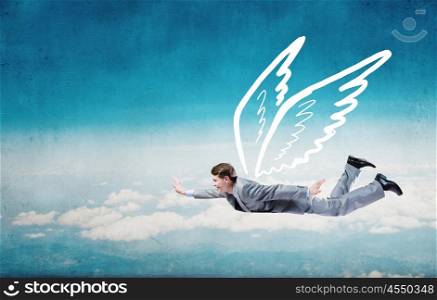 Businessman flying high. Young businessman with drawn wings flying in sky
