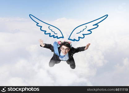 Businessman flying high. Young businessman with drawn wings flying in sky