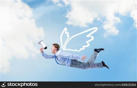Businessman flying high. Young businessman with wings flying in sky and talking in megaphone