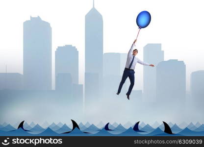 Businessman flying holding balloon