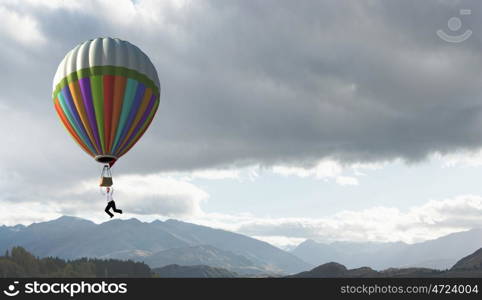 Businessman flying in search of ideas hanging on balloon. Search for new business ideas