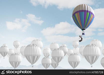 Businessman flying in search of ideas hanging on balloon. Search for new business ideas