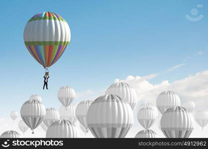 Businessman flying in search of ideas hanging on balloon. Search for new business ideas