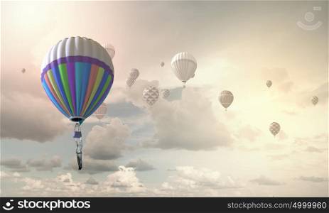 Businessman flying in search of ideas hanging on balloon. Search for new business ideas