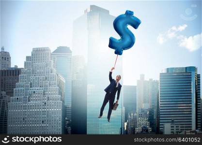 Businessman flying on dollar sign inflatable balloon