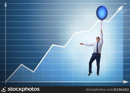 Businessman flying on hot balloon over graph