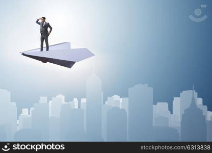 Businessman flying on paper plane in business concept