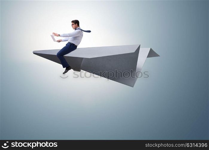 Businessman flying on paper plane in business concept. The businessman flying on paper plane in business concept