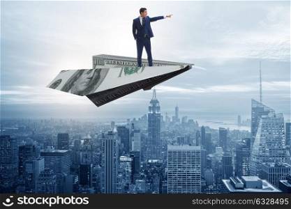 Businessman flying on paper plane in business concept. The businessman flying on paper plane in business concept