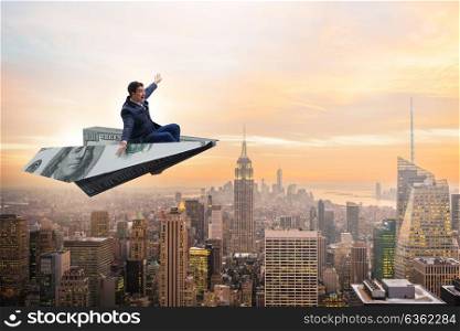Businessman flying on paper plane in business concept