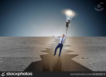Businessman flying over gap on light bulb balloon