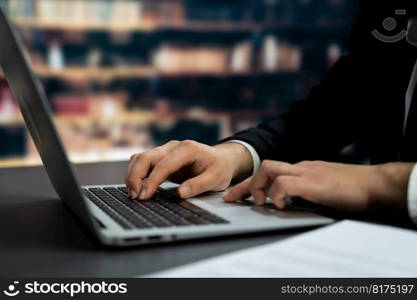 Businessman focused on his laptop working on financial report or planning business strategy in library. Modern office worker utilizing technology in the field of business. Equilibrium. Businessman focused on his laptop working on financial report. Equilibrium