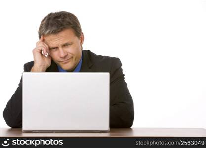 Businessman Frowning While Looking At Laptop