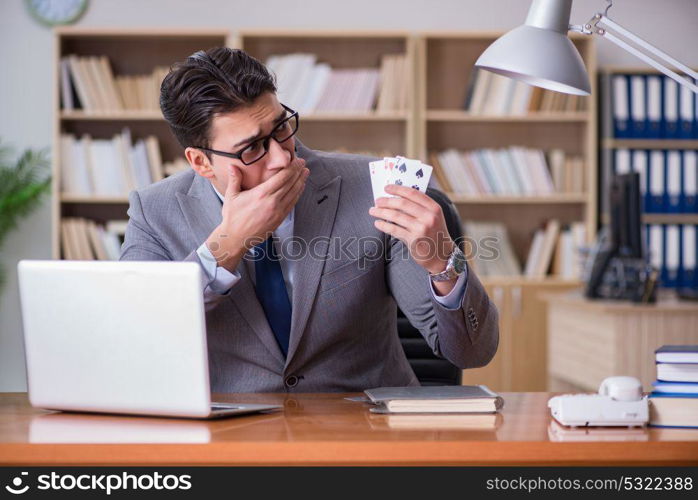 Businessman gambling playing cards at work