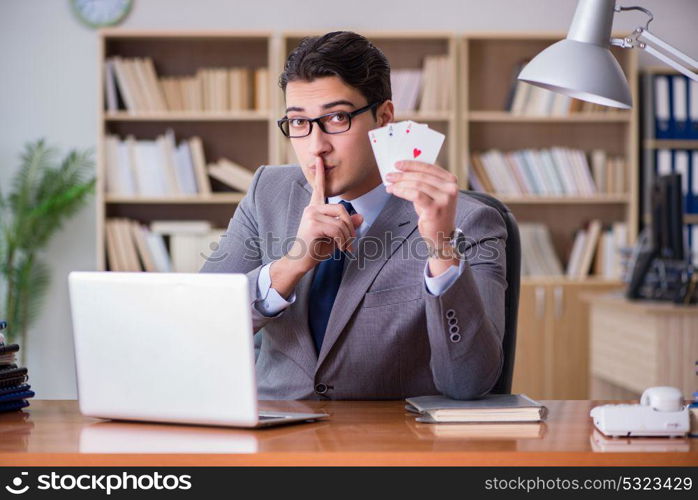 Businessman gambling playing cards at work