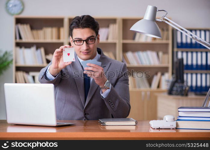 Businessman gambling playing cards at work