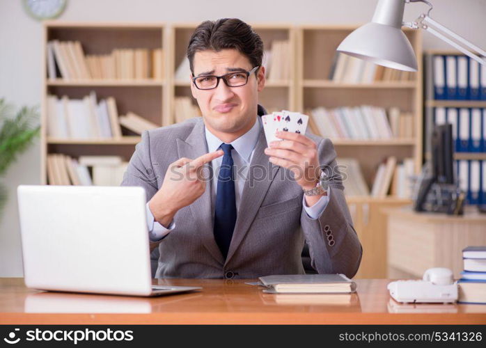 Businessman gambling playing cards at work