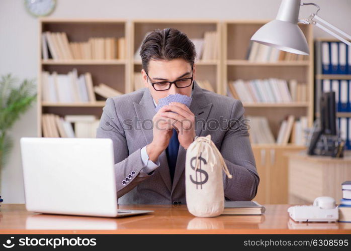 Businessman gambling playing cards at work