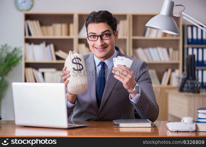 Businessman gambling playing cards at work