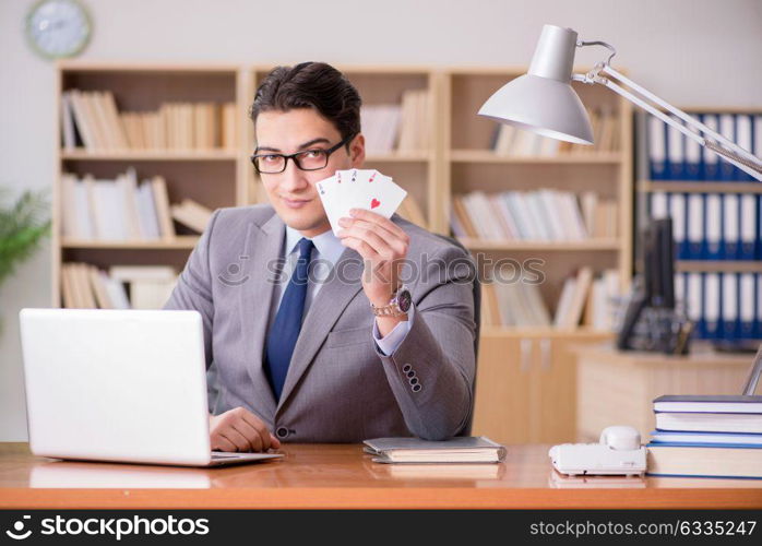 Businessman gambling playing cards at work