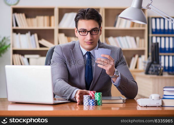 Businessman gambling playing cards at work