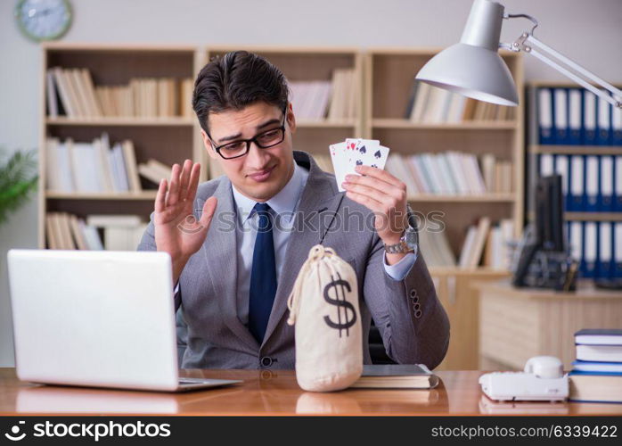 Businessman gambling playing cards at work