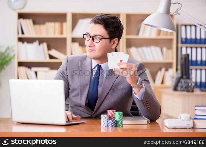 Businessman gambling playing cards at work