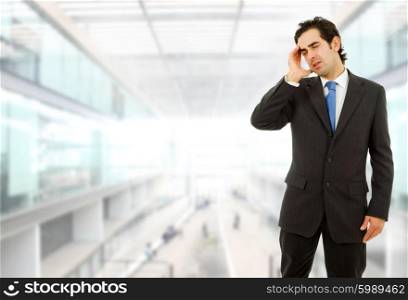 Businessman gestures with a headache, at the office