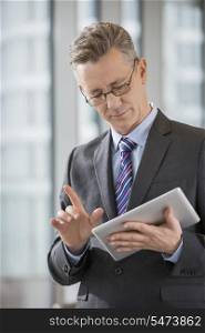 Businessman gesturing while using digital tablet in office