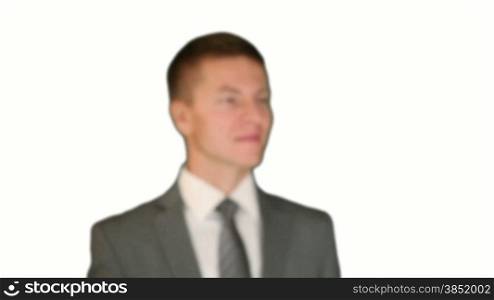 Businessman getting in focus, turns and smile, against white