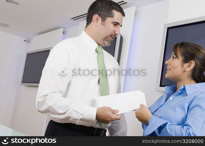 Businessman giving a document to a businesswoman