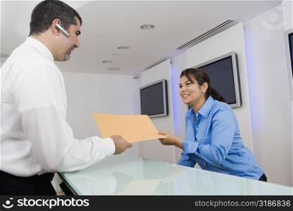 Businessman giving a file to a businesswoman