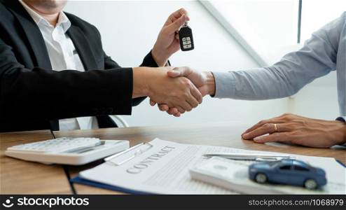 Businessman giving end key to customer after good deal agreement. while loan agreement being approved and calculator, Buy house concept.
