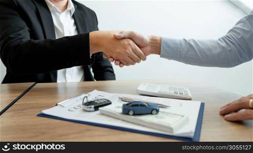 Businessman giving end key to customer after good deal agreement. while loan agreement being approved and calculator, Buy house concept.