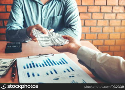 Businessman giving money to Business partner while making contract concept