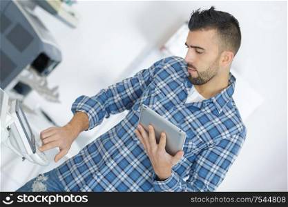 businessman giving print command on digital tablet in office