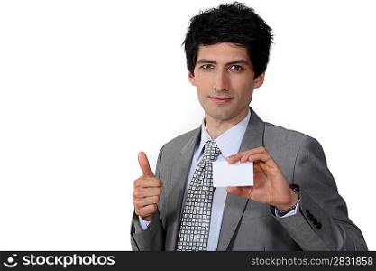 Businessman giving the thumb&acute;s up and holding a business card