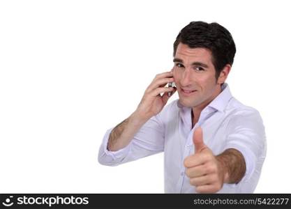 Businessman giving the thumbs-up during phone call
