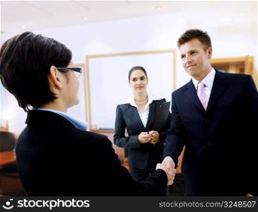Businessman greeting partner in the meeting room. Selective focus is placed on the hands.