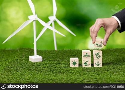 Businessman hand and arranged eco-concept wooden cube icon. Green Bio energy business with wind turbine for environmental conservation and sustainable and renewable energy for households. Alter. Businessman hand and arranged eco-concept wooden cube icon. Alter