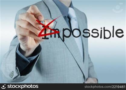 Businessman hand changing the word impossible into possible
